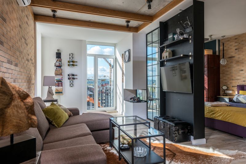 A furnished living room with a sofa, coffee table, and a wall-mounted television